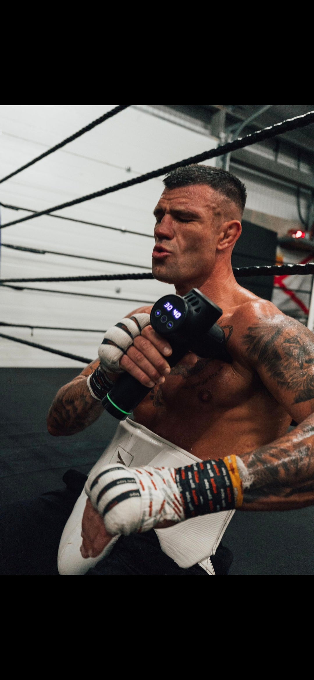 Athlete using massage gun after training